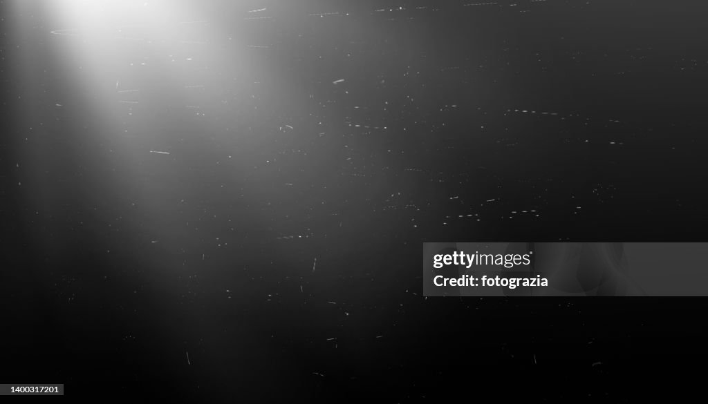 Scratches and Dust on Black Background with Light Rays