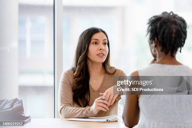 female therapist listens to unrecognizable woman - employee review imagens e fotografias de stock