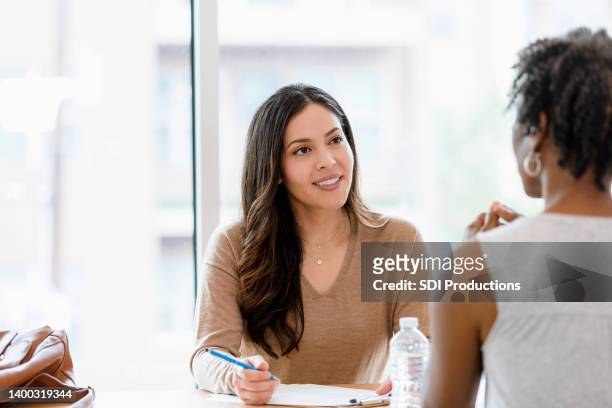 mid adult female manager interviews unrecognizable woman for job - psychotherapy stock pictures, royalty-free photos & images