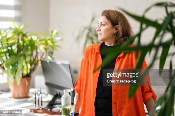 porträt einer geschäftsfrau in ihrem grünen büro für umweltschützer - woman with orange stock-fotos und bilder