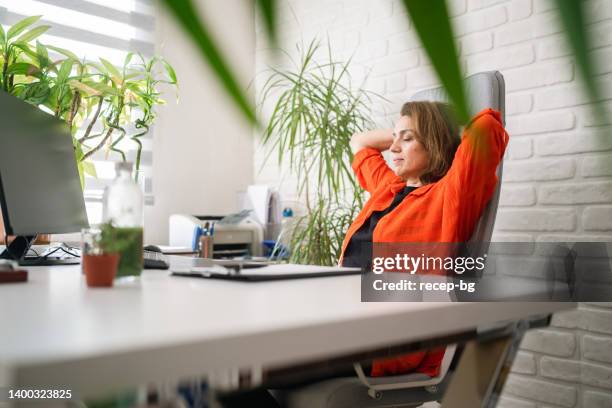 businesswoman taking a break and resting with her eyes closed in her office - reusable water bottle office stock pictures, royalty-free photos & images