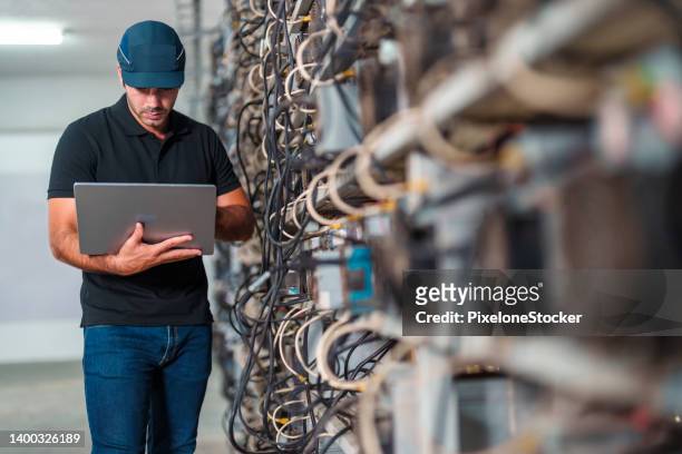 professional engineers carrying the laptop working in crypto mine. - bitcoin mining imagens e fotografias de stock
