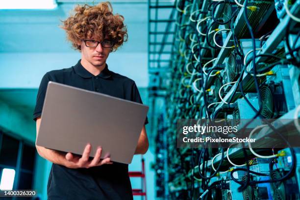 professional engineers carrying the laptop working in crypto mine. - computer cable stock-fotos und bilder