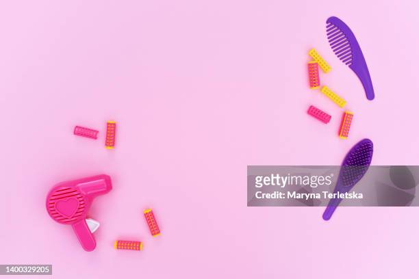 toy hair dryer, hairbrush and curlers on a pink background. master hairdresser. beauty saloon. beauty industry concept. children's girly toys. - hair color saloon stock pictures, royalty-free photos & images