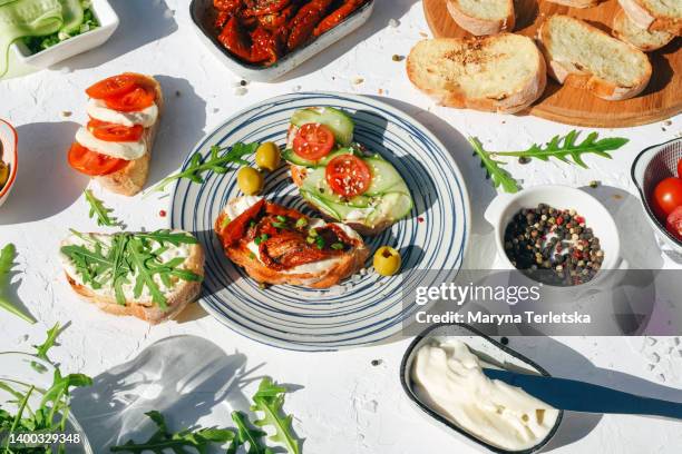 a variety of healthy toasts with vegetables, seeds and microgreens. colorful, plant-based vegan snacks. stylish table setting and food. catering. food delivery. festive table. - spread stock-fotos und bilder