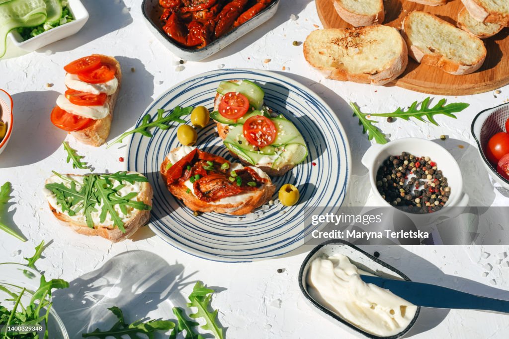 A variety of healthy toasts with vegetables, seeds and microgreens. Colorful, plant-based vegan snacks. Stylish table setting and food. Catering. Food delivery. Festive table.