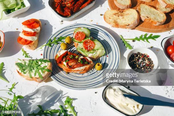 a variety of healthy toasts with vegetables, seeds and microgreens. colorful, plant-based vegan snacks. stylish table setting and food. catering. food delivery. festive table. - spread food fotografías e imágenes de stock