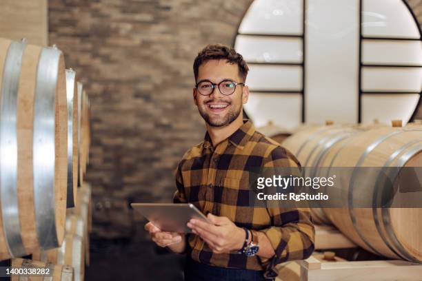 porträt eines glücklichen unternehmers, der das geschäft in seinem weingut führt - tablet alcohol stock-fotos und bilder
