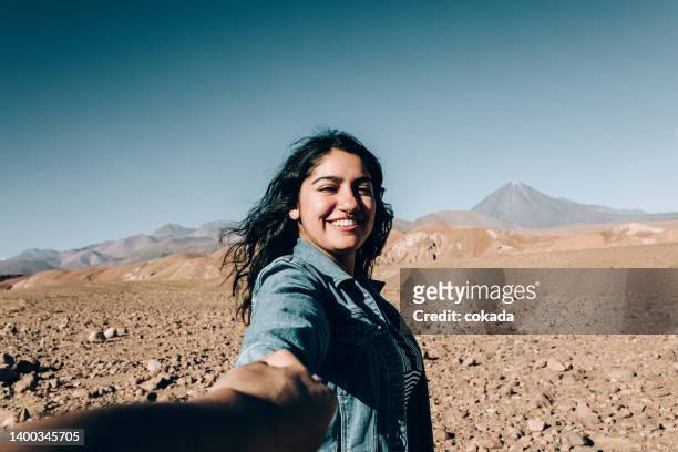 young chilean woman holding viewer´s hand at atacama desert - s the adventures of rin tin tin stockfoto's en -beelden