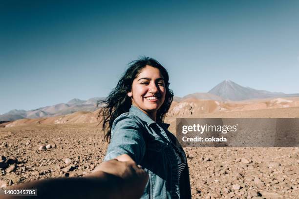 young chilean woman holding viewer´s hand at atacama desert - antofagasta region stock pictures, royalty-free photos & images