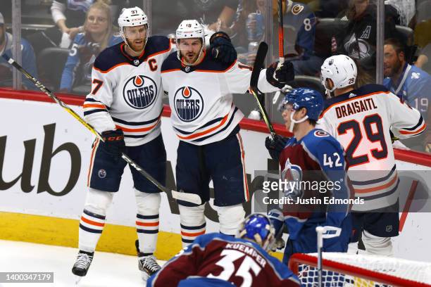 Zach Hyman of the Edmonton Oilers celebrates a goal with his teammates Connor McDavid and Leon Draisaitl against Darcy Kuemper of the Colorado...