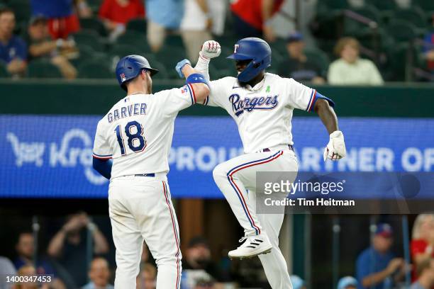 Adolis Garcia of the Texas Rangers celebrates his two-run home run at home plate with Mitch Garver in the fourth inning against the Tampa Bay Rays at...