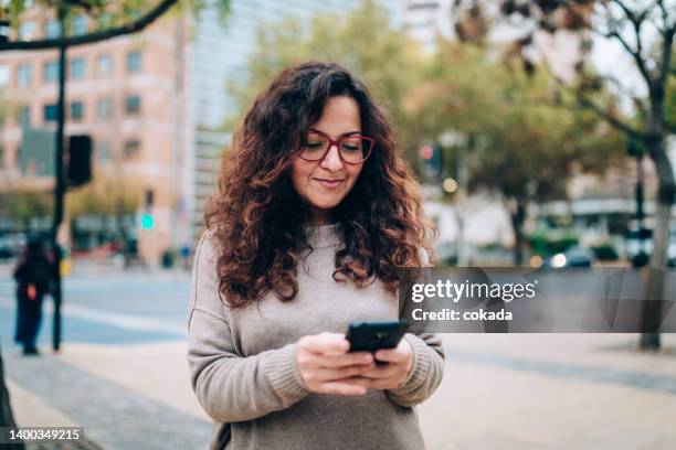 mujer chilena usa celular en las calles de santiago - chilean people fotografías e imágenes de stock