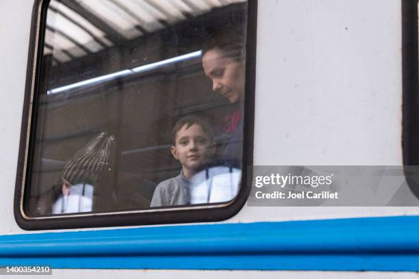 young boy departing ukraine looking out window at lviv train station - ukraina stock pictures, royalty-free photos & images