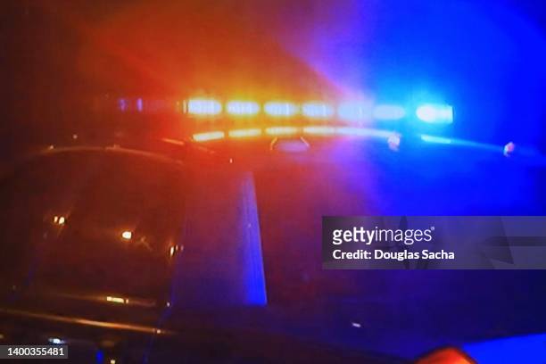 police car - fast moving with bright flashing lights - sirene stockfoto's en -beelden
