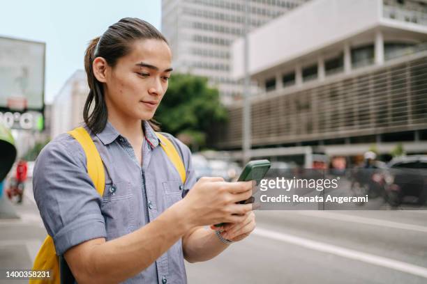 ブラジル・サンパウロ州パウリスタ・アベニューでスマートフォンを利用する日本人大学生 - 美大生　日本 ストックフォトと画像