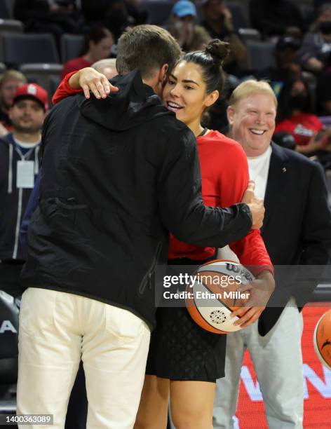 Tampa Bay Buccaneers quarterback Tom Brady hugs Kelsey Plum of the Las Vegas Aces as Las Vegas Raiders owner and managing general partner and Las...