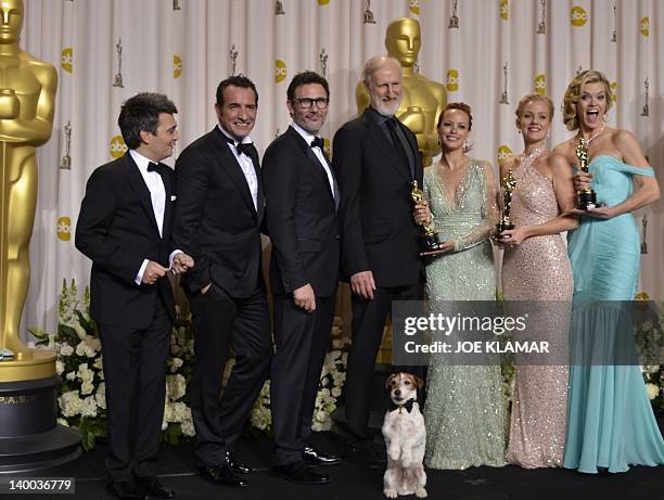 Uggie the dog from winner of Best Picture, "The Artist" poses with cast members in the press room at the 84th Annual Academy Awards on February 26,...