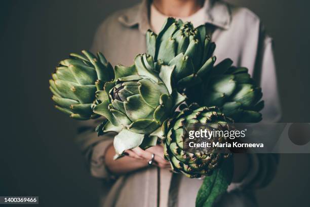 woman holding artichoke - artichoke stock pictures, royalty-free photos & images