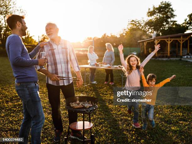 happy extended family having a barbecue garden party at sunset. - european spring bildbanksfoton och bilder
