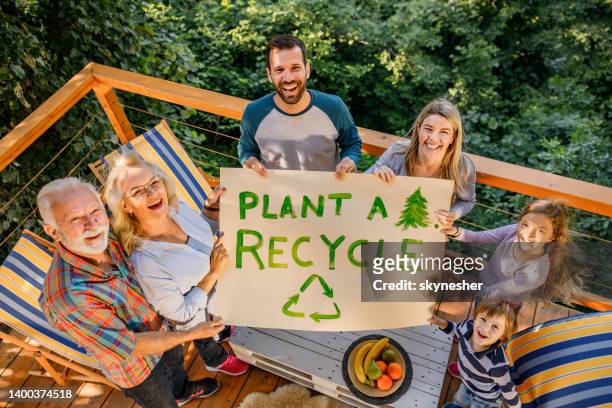 plant a tree and recycle! - family planting tree stockfoto's en -beelden