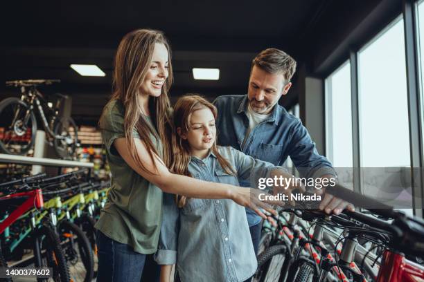 family looking for bike in bike shop - buying a bike bildbanksfoton och bilder