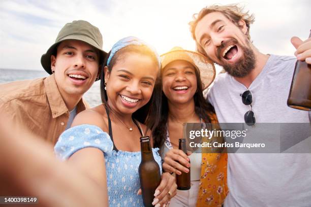 beautiful photo of four friends having fun at the beach and taking a selfie. - four people stock-fotos und bilder