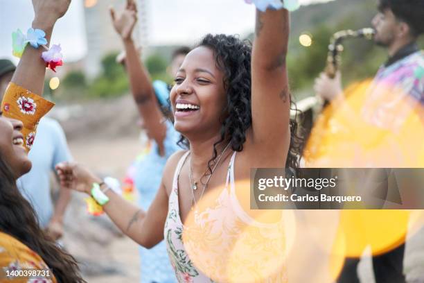 cheerful photo of an african american young woman dancing in a beach party in the summer season. - outside lands music arts festival stock-fotos und bilder