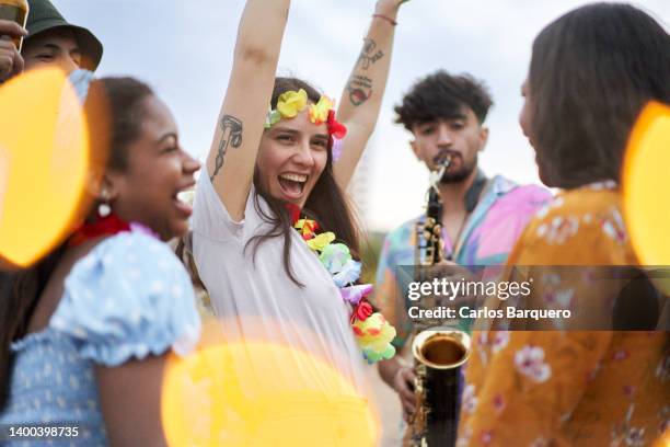 group of multiethnic friends dancing in an open air party. - carnivale stock-fotos und bilder