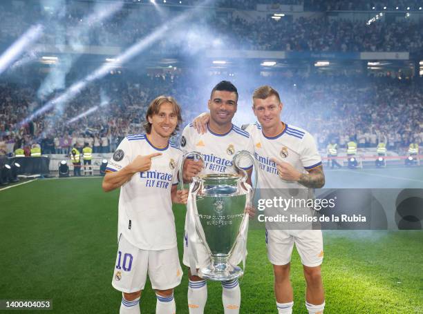 Luka Modric, Carlos Casemiro and Toni Kroos players of Real Madrid are posing with the UEFA Champion League trophy at Santiago Bernabeu Stadium on...