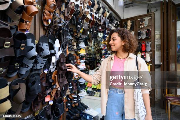 mitte der 20er jahre jeddah frau kauft sandalen im souk ein - bazaar market stock-fotos und bilder
