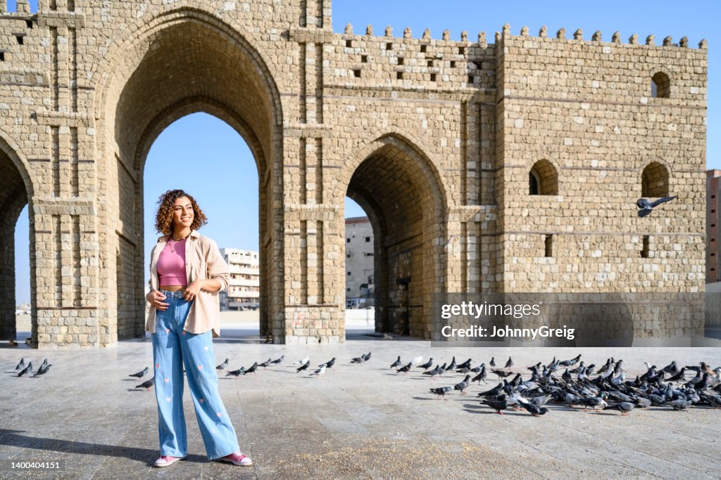 Smiling young woman standing at Jeddah gateway monument