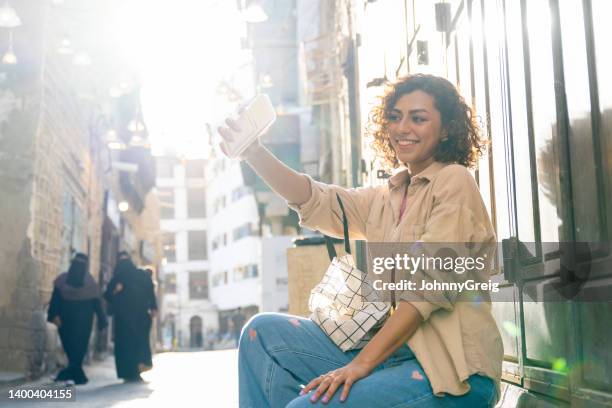 mid 20s saudi woman taking selfie outdoors in sunny jeddah - ksa people stock pictures, royalty-free photos & images
