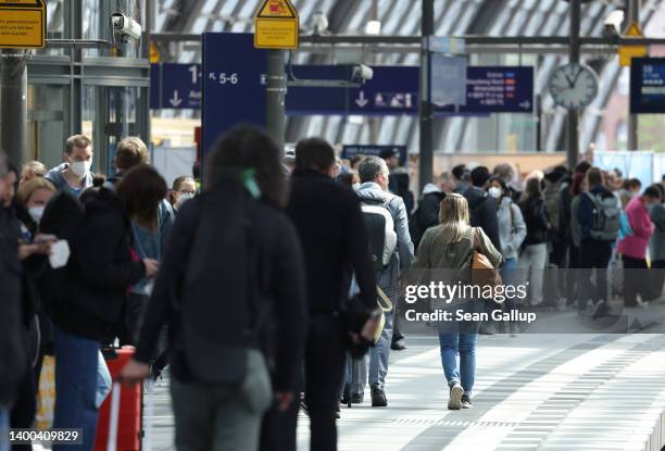 Travellers stand on a platform as they wait for the arrival of a commuter S-Bahn train on the first validity day of the new 9 Euro monthly rail...