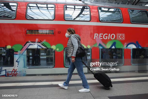 Traveller pulls her suitcase on a platform following the arrival of a regional train on the first validity day of the new 9 Euro monthly rail ticket...