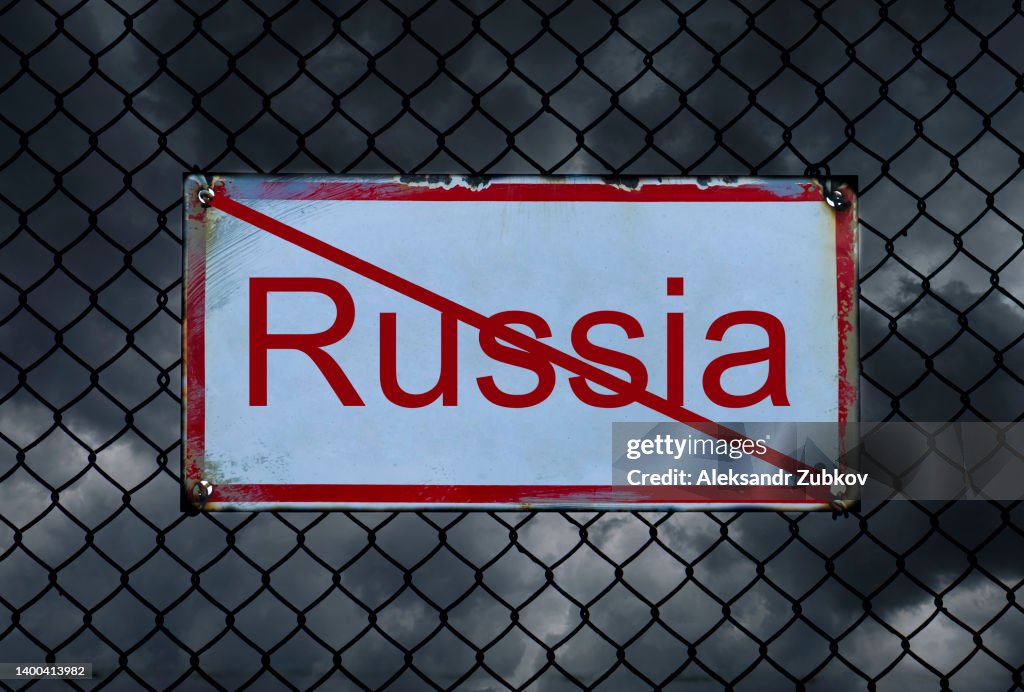 Black thickening clouds and a crossed-out inscription "Russia", against a background of barbed wire. Sanctions against the country. Problems, economic and financial crisis due to military actions and offenses.