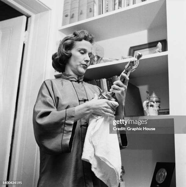 American actress Kim Hunter polishing her Oscar statuette at home in New York City, New York, 30th January 1956. Hunter won the Academy Award for...