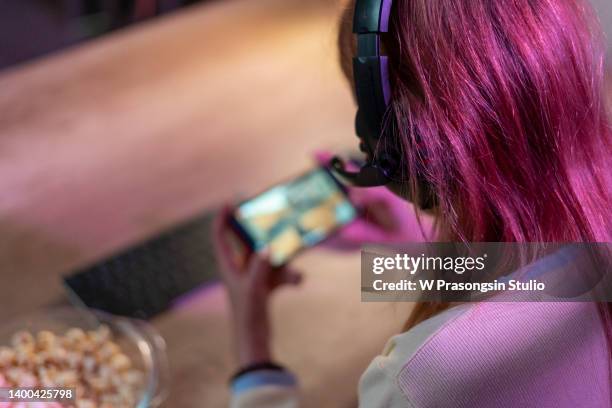happy girl gamer wear headphone competition video game online with smartphone - jeu mobile photos et images de collection