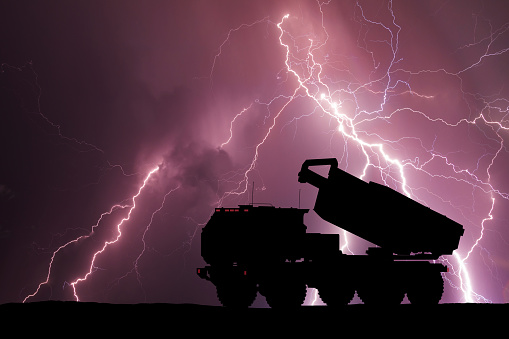 Multiple launch rocket system on the background of stormy sky with lightning