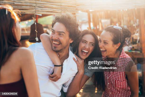 amici in un campo da spiaggia - maschio con gruppo di femmine foto e immagini stock