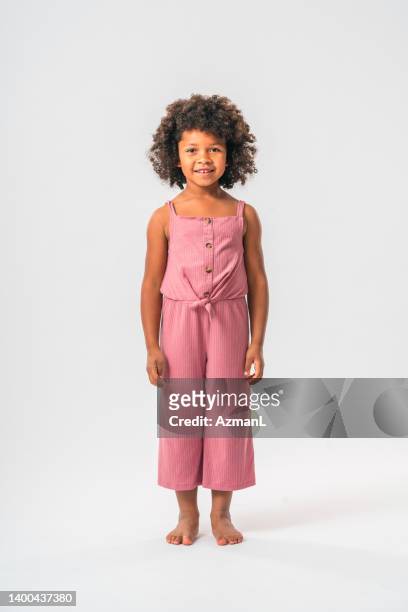 african girl standing and smiling - girls barefoot in jeans stockfoto's en -beelden