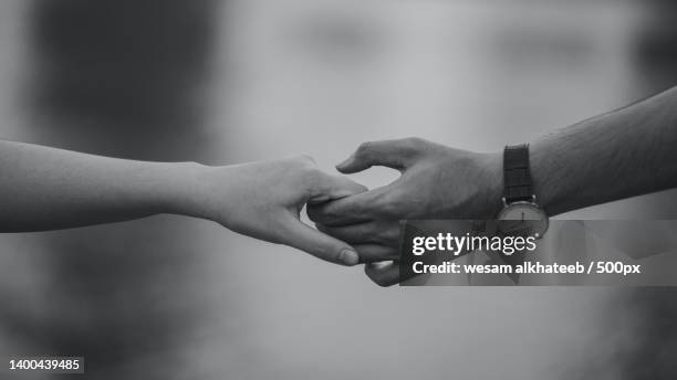 cropped image of couple holding hands - black and white holding hands stock pictures, royalty-free photos & images