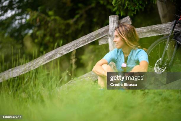 young woman with mountain bike on italian mountains: resting in the nature - cycling vest stock pictures, royalty-free photos & images