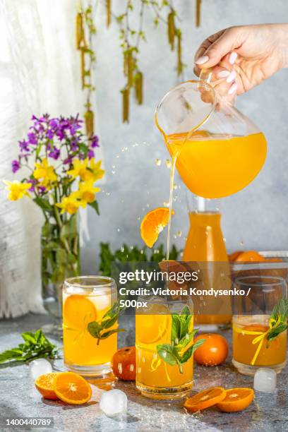 glasses of tasty cocktail with tangerine and ice with splash - tangerine martini stock pictures, royalty-free photos & images