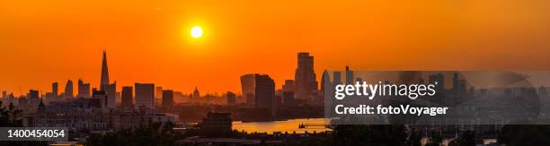 london golden sunset silhouetting city skyscrapers historic landmarks thames panorama - london sun stock pictures, royalty-free photos & images