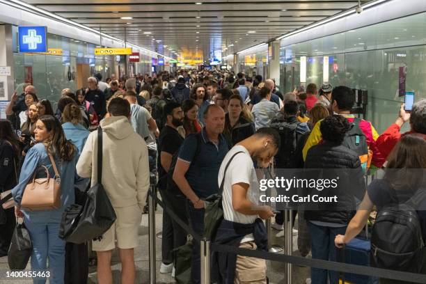 Travellers wait in a long queue to pass through the security check at Heathrow on June 1, 2022 in London, England. The aviation industry is...