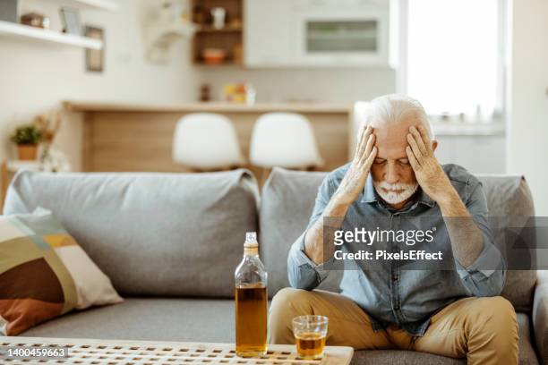 senior man drinking alcohol at home - alcoholic stock pictures, royalty-free photos & images