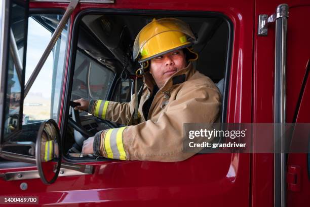 消防署の若い消防士は、完全な防火具、投票率、消防車付き - fire station ストックフォトと画像