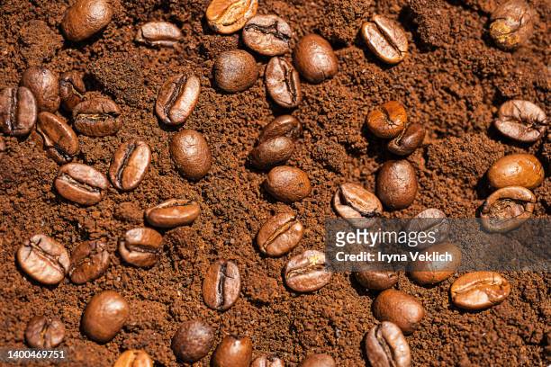 roasted coffee beans on the background of the texture of ground coffee. macrophotography. - caffettiera foto e immagini stock