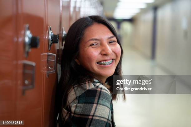 adolescente souriante au lycée dans son casier dans le couloir de l’école, regardant le portrait de la caméra - indian youth photos et images de collection